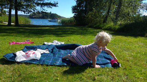 Cute girl playing on fabric in garden during sunny day