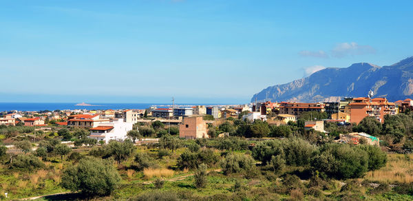 High angle view of townscape by sea against sky