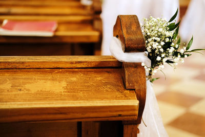 Benches in church decorated with white flowers and fabric for a wedding