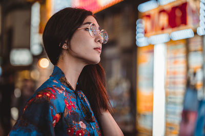 Portrait of young woman looking away outdoors