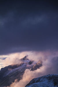 Snow covered landscape against clouds