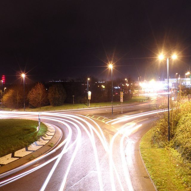 illuminated, transportation, night, light trail, the way forward, long exposure, road, diminishing perspective, speed, vanishing point, motion, street light, clear sky, blurred motion, road marking, outdoors, no people, lighting equipment, street, sky
