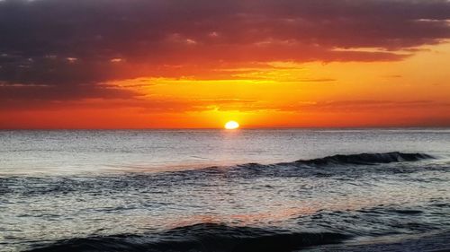 Scenic view of sea against orange sky