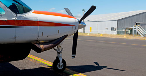 Airplane on airport runway against sky