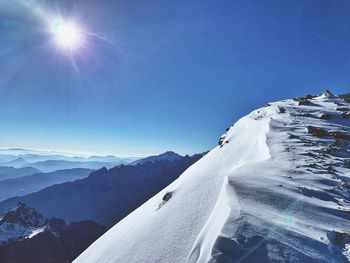 Scenic view of snowcapped mountains against blue sky