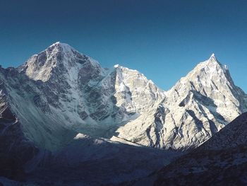 Scenic view of snowcapped mountains against clear blue sky