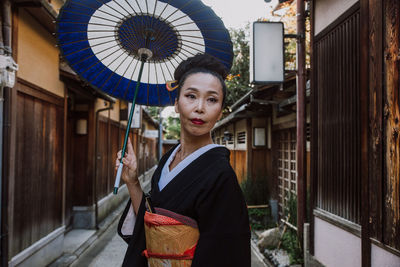 Portrait of woman standing against built structure