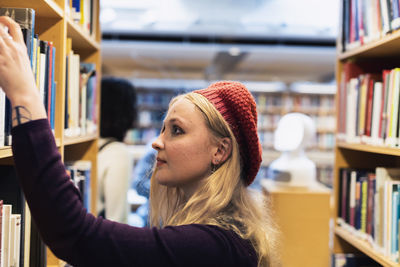 Female student searching for books in library