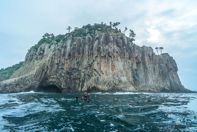 Rock formation in sea against sky