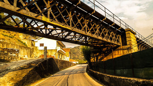 Road by bridge against sky