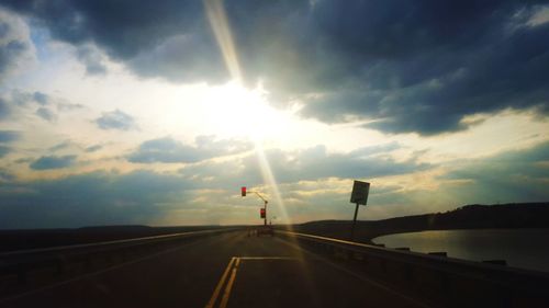 Road against cloudy sky at sunset