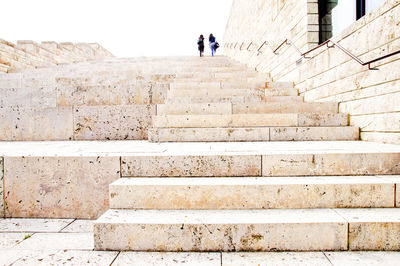 Low angle view of friends walking on staircase