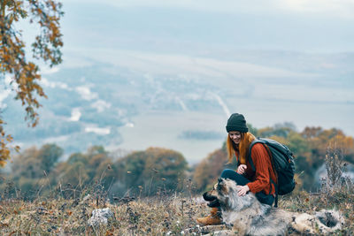 Young woman with dog in the background