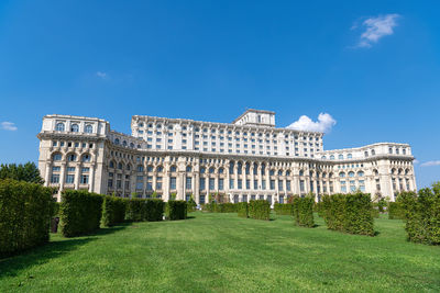 Buildings on field against sky