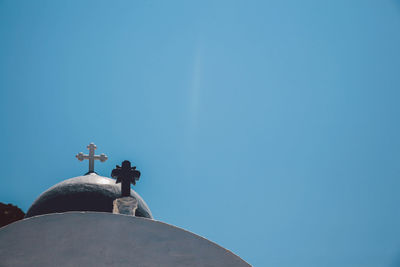 Low angle view of cross on church against clear blue sky at santorini