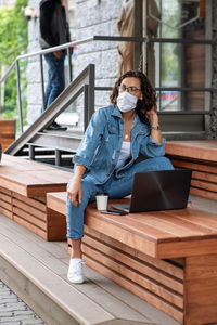 Full length of woman sitting outdoors