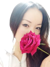 Close-up of woman holding pink flower