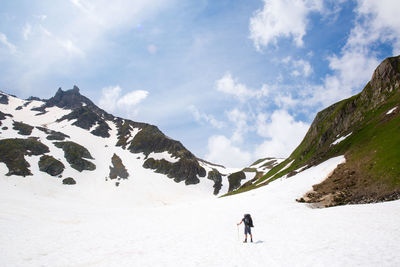 Full length of person standing on snowcapped mountains against sky