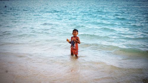 Portrait of happy girl standing on beach