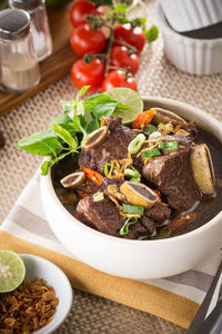 High angle view of konro soup served in bowl with fork and spoon on table
