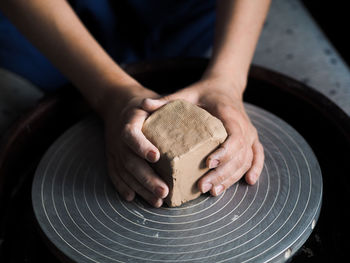Woman starts to create a ceramic cup on the pottery wheel. working with clay on potter's wheel.