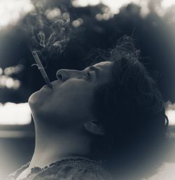 Close-up portrait of woman smoking cigarette