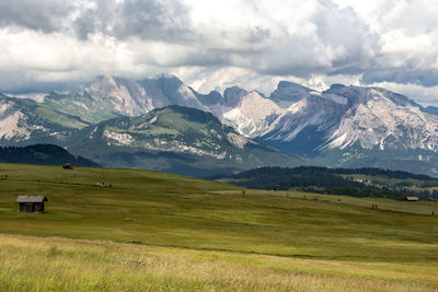 Scenic view of field and mountains against sky