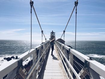 Long leading to sea against sky