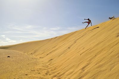 Man jumping a dune at corralejo