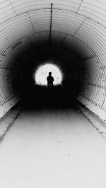 Rear view of silhouette person in tunnel