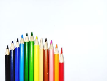 Close-up of colored pencils against white background