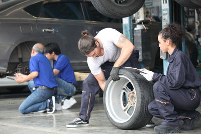 Mechanics repairing tire at garage