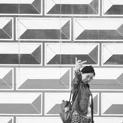 Full length of woman standing against wall