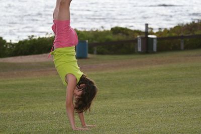 Full length of woman climbing on grass