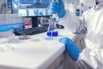 Midsection of scientist working in laboratory