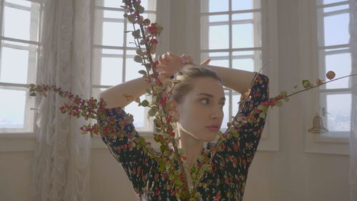 Portrait of young woman seen through window