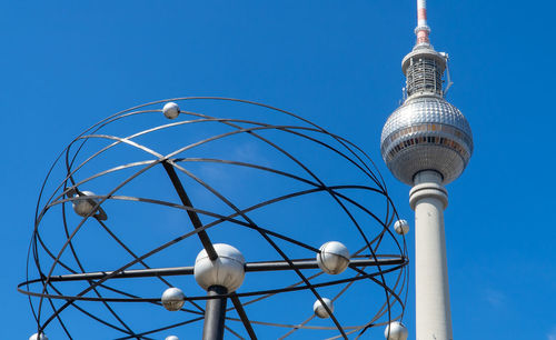 Low angle view of communications tower against blue sky