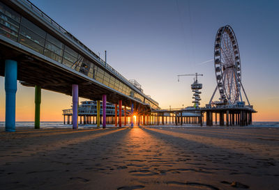 View of beach against clear sky at sunset