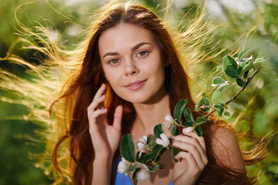 Portrait of smiling young woman sitting on field