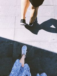 Low section of women walking on footpath