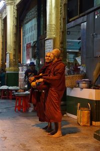 Rear view of woman with umbrella walking in city