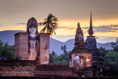 Old temple building against sky during sunset