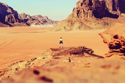 Rear view of man walking on rock