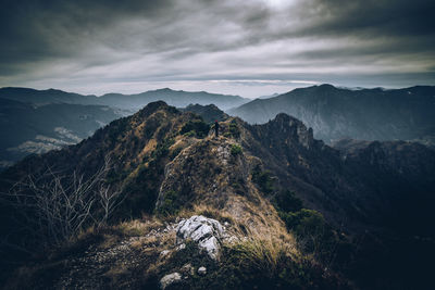 Scenic view of man on mountains against sky