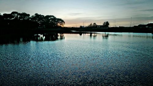 Scenic view of river against sky at sunset