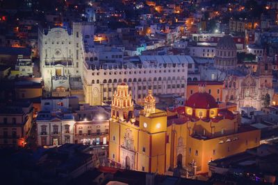 High angle view of illuminated colonial style buildings in city at dusk