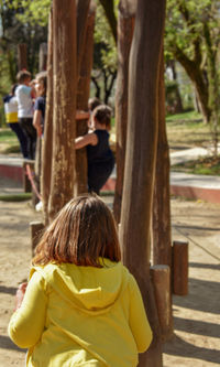 Rear view of people on tree trunk