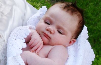 Close-up of cute child lying at lawn