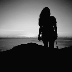 Rear view of silhouette woman standing on beach