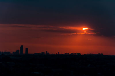 Silhouette buildings against sky during sunset